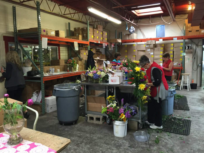 Workers arrange bouquets for a Goquets regional partner and Des Moines-area florist Boesen The Florist.