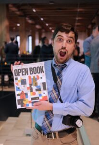 SPN reporter Ben Goeser holds a copy of “Open Book.” Photo by Lev Gringauz/Silicon Prairie News